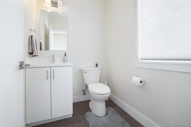 bathroom with hardwood / wood-style floors, toilet, and vanity