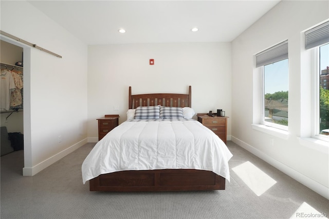 carpeted bedroom featuring a walk in closet and a closet