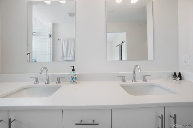 bathroom with tiled shower and vanity