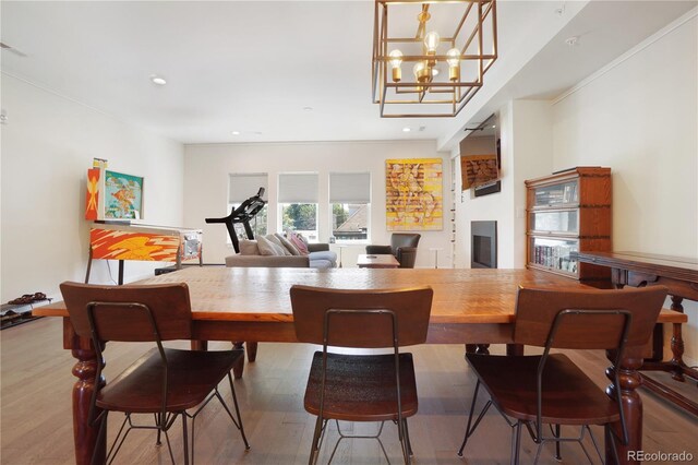 dining space featuring crown molding, wood-type flooring, and a chandelier