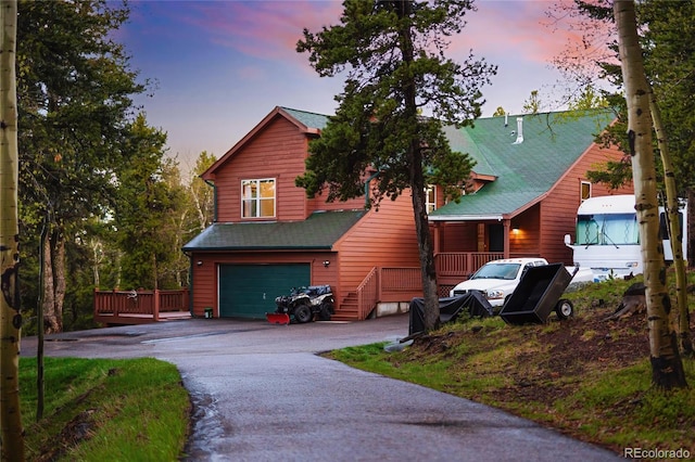 11163 Conifer Mountain Rd, Conifer, CO 80433 - rustic home with asphalt driveway and an attached garage