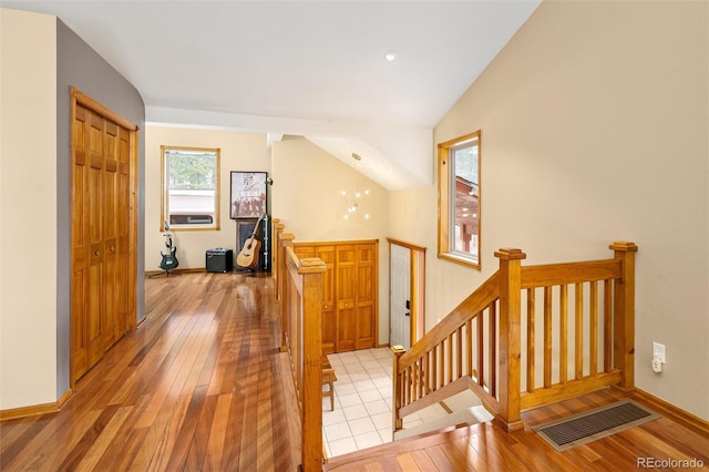 11163 Conifer Mountain Rd, Conifer, CO 80433 - corridor featuring an upstairs landing, light wood finished floors, baseboards, cooling unit, and lofted ceiling