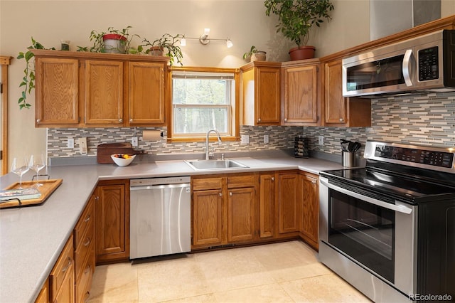 11163 Conifer Mountain Rd, Conifer, CO 80433 - kitchen with appliances with stainless steel finishes, tasteful backsplash, light countertops, brown cabinetry, and light tile patterned flooring