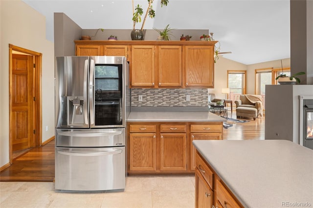11163 Conifer Mountain Rd, Conifer, CO 80433 - kitchen featuring stainless steel refrigerator with ice dispenser, vaulted ceiling, light countertops, and decorative backsplash