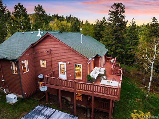11163 Conifer Mountain Rd, Conifer, CO 80433 - back of house at dusk with a wooden deck and a shingled roof