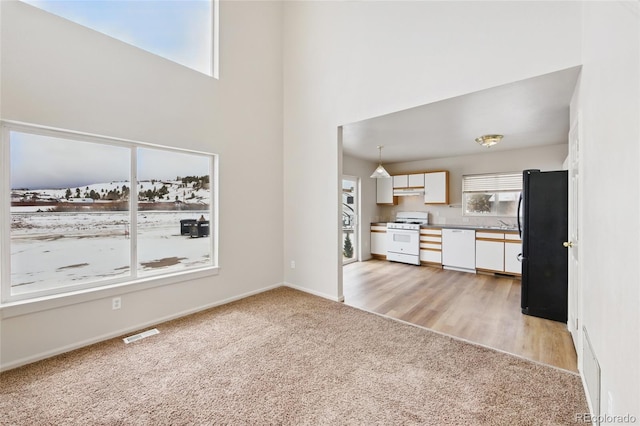 109 Gcr 823, Tabernash, CO 80478 - unfurnished living room featuring light carpet, a high ceiling, baseboards, and a sink