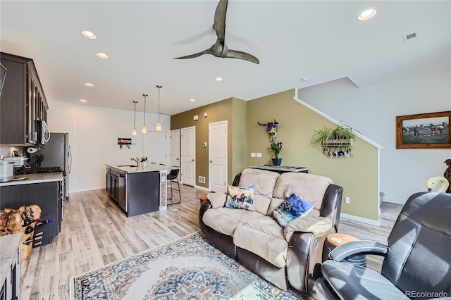 living area with light wood finished floors, recessed lighting, visible vents, and a ceiling fan