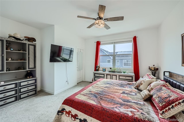 bedroom featuring a ceiling fan, light colored carpet, and baseboards