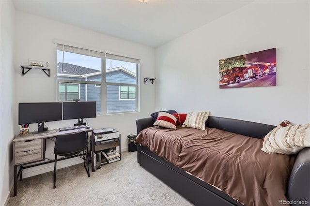 bedroom featuring light carpet and baseboards