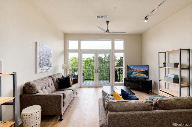 living room featuring ceiling fan, light hardwood / wood-style flooring, track lighting, and french doors