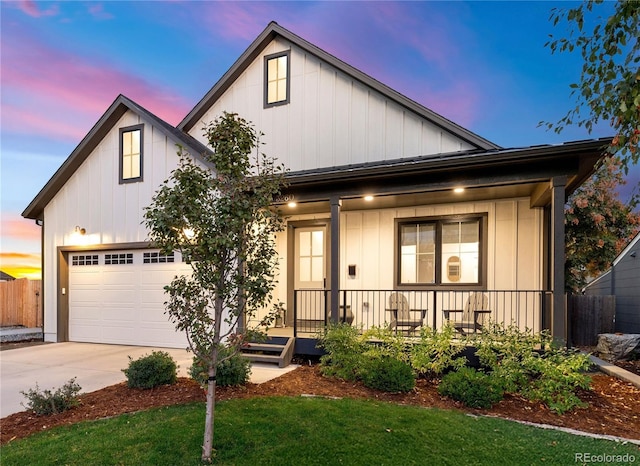 view of front of property featuring a lawn, covered porch, and a garage