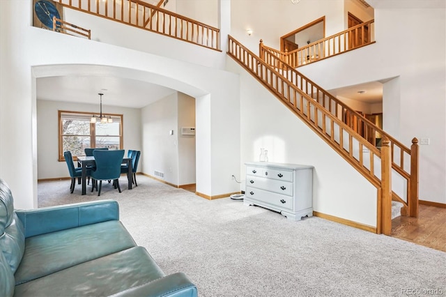 carpeted living room featuring a high ceiling