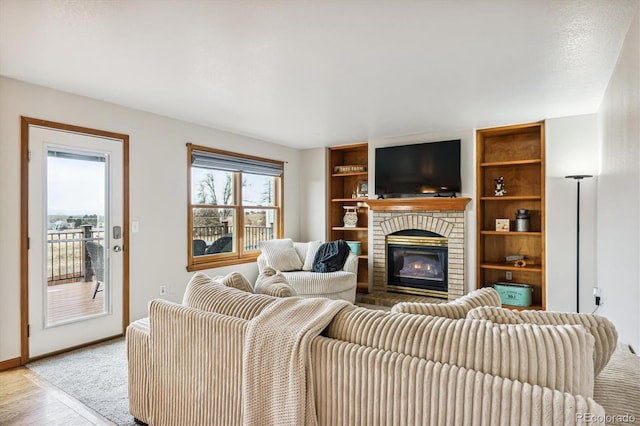 living room with a brick fireplace and light hardwood / wood-style flooring