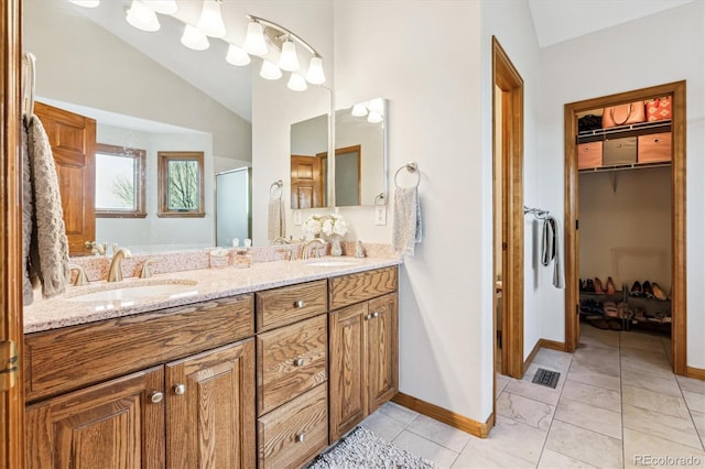 bathroom with lofted ceiling, vanity, tile patterned floors, and a shower with door