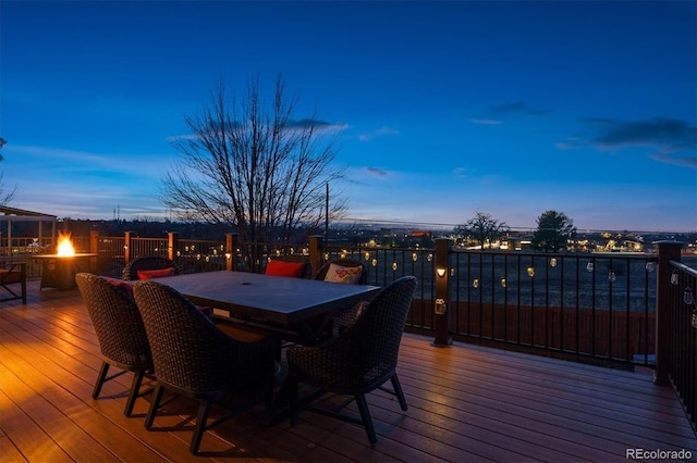 deck at dusk featuring a fire pit