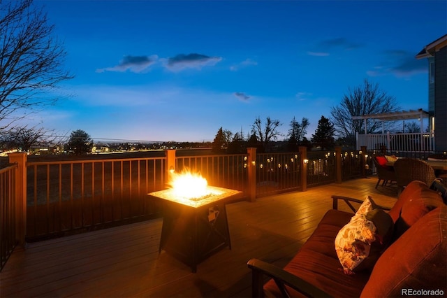 patio terrace at dusk with an outdoor fire pit and a deck