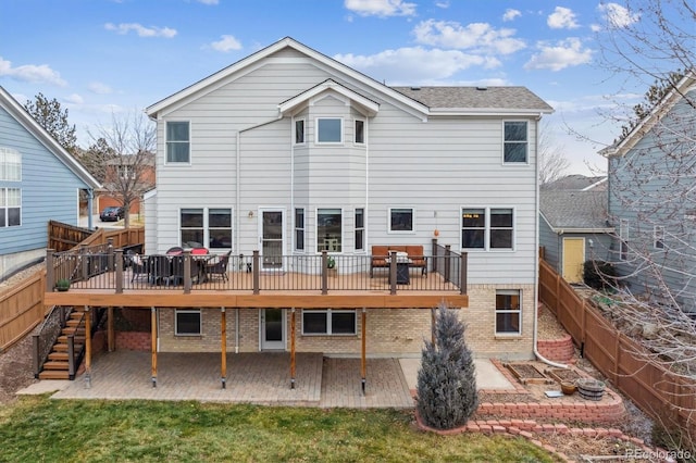 back of house with a wooden deck, a lawn, and a patio area