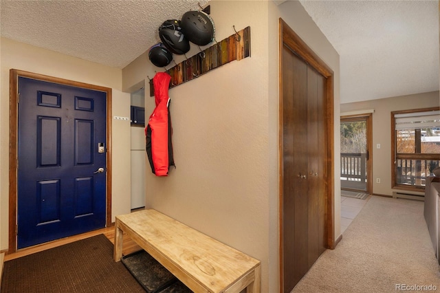 mudroom featuring light carpet, a baseboard heating unit, and a textured ceiling