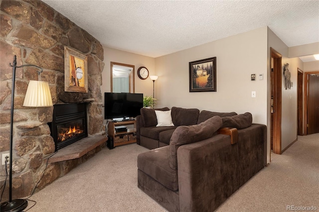 carpeted living room featuring a textured ceiling and a stone fireplace