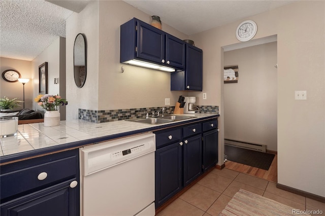 kitchen featuring light tile patterned floors, tile countertops, a baseboard radiator, dishwasher, and sink