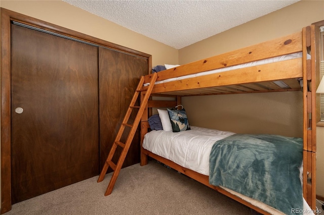 bedroom featuring a textured ceiling, a closet, and carpet floors