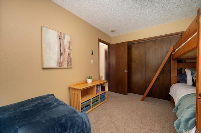 carpeted bedroom with a textured ceiling and a closet