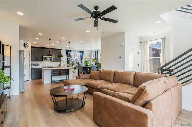 living room featuring ceiling fan and light wood-type flooring