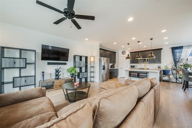 living room featuring ceiling fan and light wood-type flooring