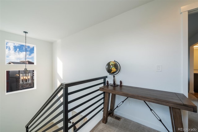 stairs featuring carpet flooring and a notable chandelier