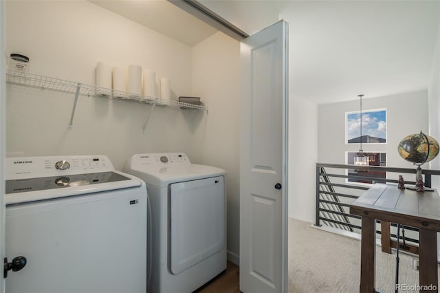 washroom featuring carpet floors, washer and dryer, and a chandelier