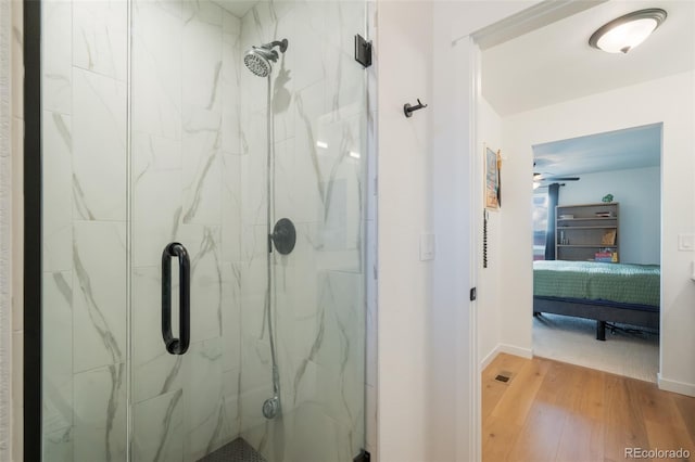 bathroom with hardwood / wood-style floors and a shower with shower door