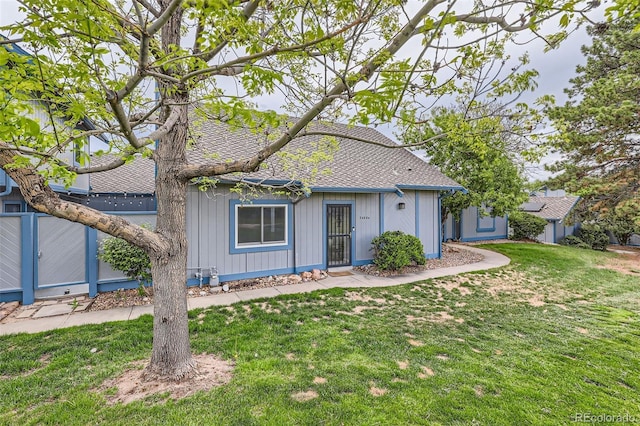 view of front of property featuring a front yard and a shingled roof