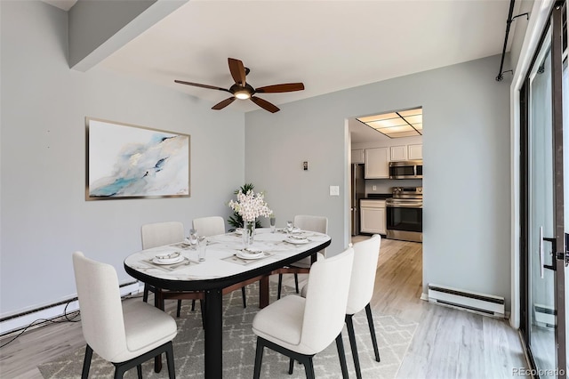 dining space featuring baseboard heating, light wood-style flooring, and a ceiling fan