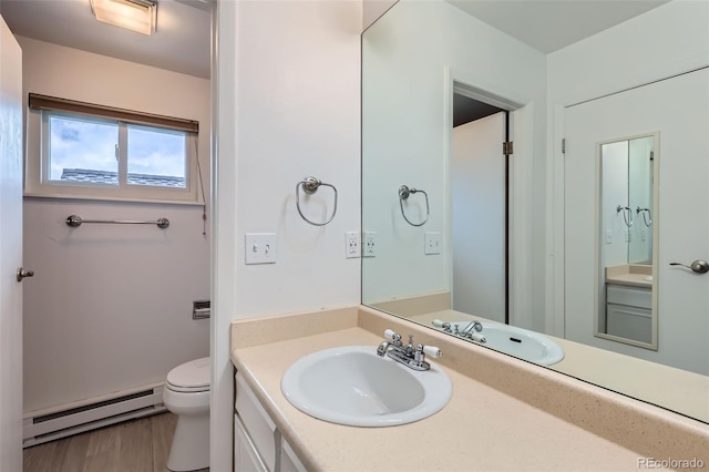 bathroom featuring a baseboard radiator, vanity, toilet, and wood finished floors