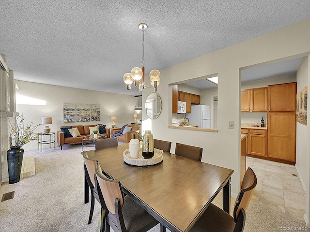 dining space featuring a textured ceiling, light colored carpet, and an inviting chandelier