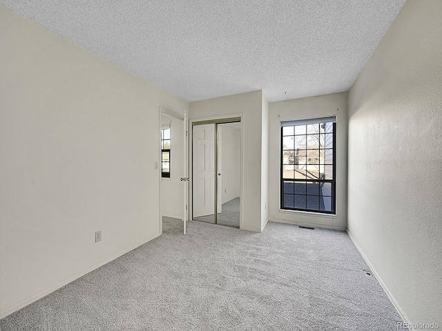 carpeted spare room with a textured ceiling