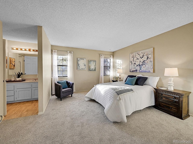 carpeted bedroom featuring connected bathroom and a textured ceiling