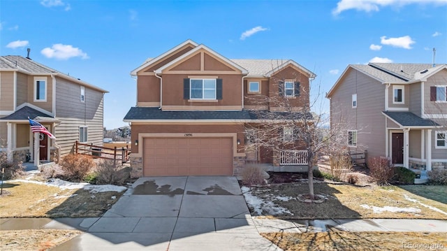 view of front of house featuring a garage, stone siding, driveway, and stucco siding