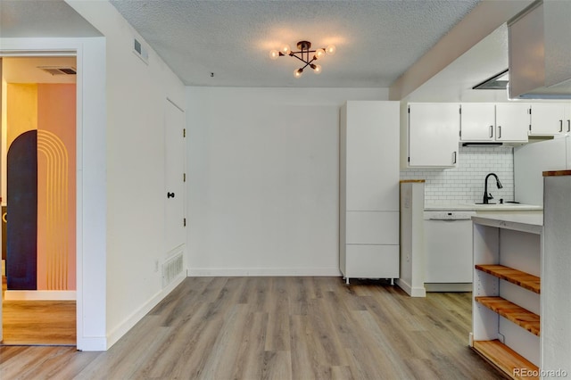 8555 Fairmount Dr Unit C202, Denver, CO 80247 - kitchen with dishwasher, a sink, light wood-style floors, light countertops, and tasteful backsplash
