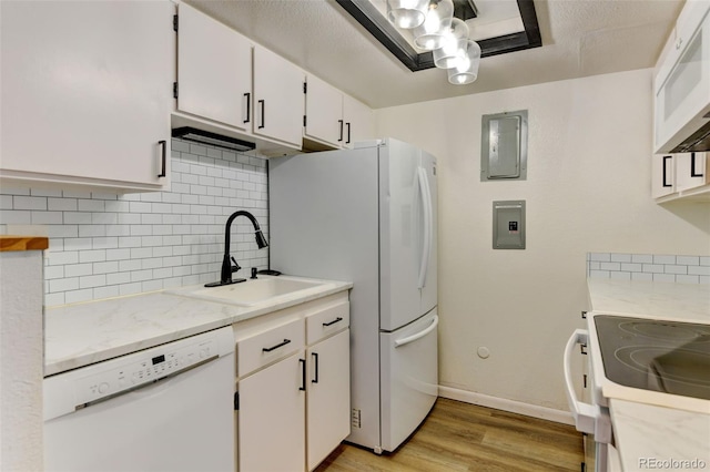 8555 Fairmount Dr Unit C202, Denver, CO 80247 - kitchen featuring white appliances, a sink, light wood finished floors, tasteful backsplash, and light countertops
