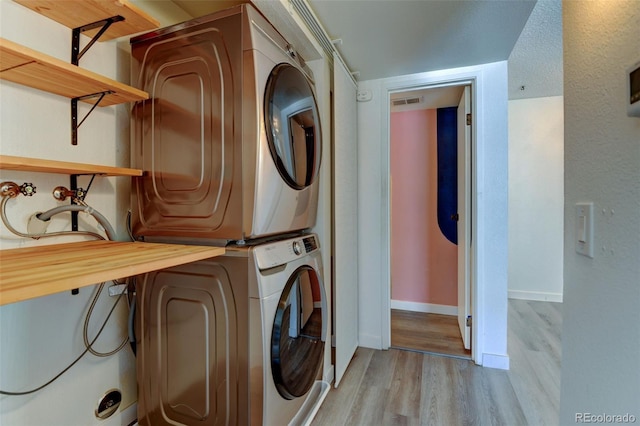 8555 Fairmount Dr Unit C202, Denver, CO 80247 - laundry room with stacked washer / dryer, light wood-style flooring, and baseboards