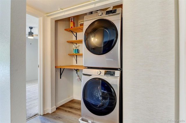 8555 Fairmount Dr Unit C202, Denver, CO 80247 - washroom with estacked washer and dryer, wood finished floors, ceiling fan, and baseboards