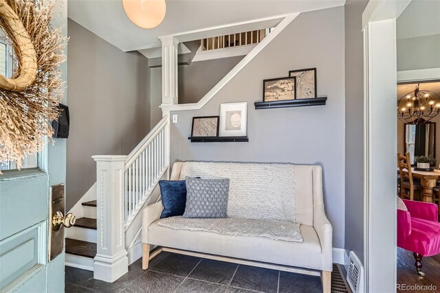 interior space featuring an inviting chandelier, baseboards, visible vents, and stairway