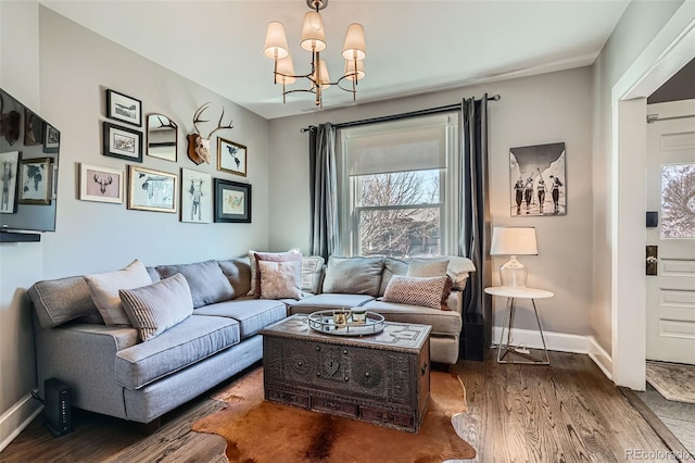 living area with a chandelier, wood finished floors, and baseboards