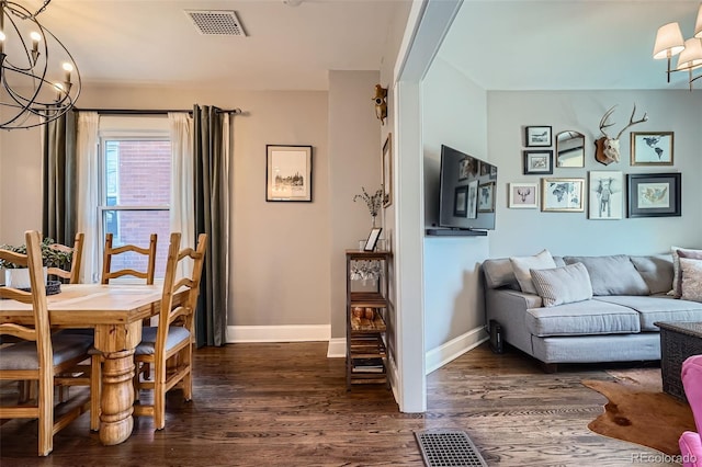 dining room featuring dark wood-style floors, baseboards, visible vents, and a notable chandelier