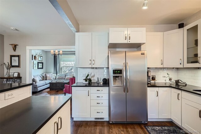 kitchen with dark wood-style floors, dark countertops, glass insert cabinets, white cabinets, and stainless steel fridge with ice dispenser