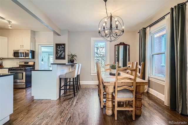 dining room with dark wood-type flooring, an inviting chandelier, and baseboards