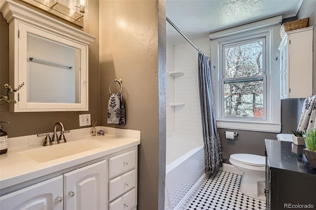 full bath featuring shower / bath combo, baseboards, toilet, a textured ceiling, and vanity