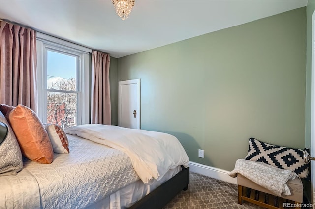 bedroom featuring dark colored carpet and baseboards