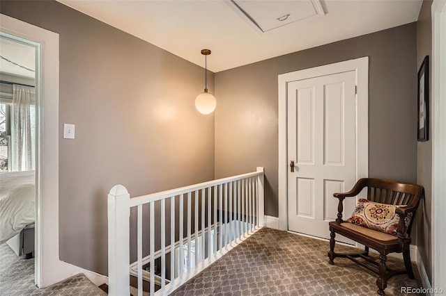 corridor featuring carpet flooring, an upstairs landing, and baseboards